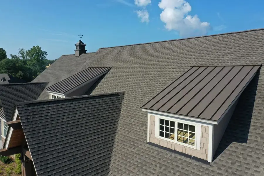 Home with standing-seam metal roofing and architectural shingles