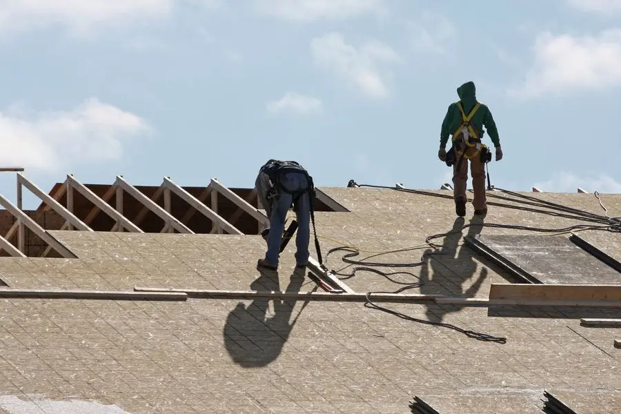 Oklahoma Exteriors roofing crew installing shingles with safety equipment